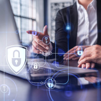 Two people sitting in front of laptop with illustration of lock and safety symbol