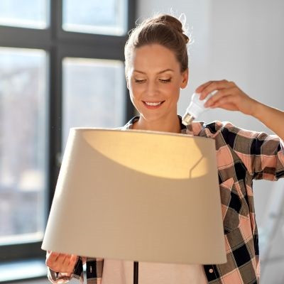 Woman installing a lightbulb.