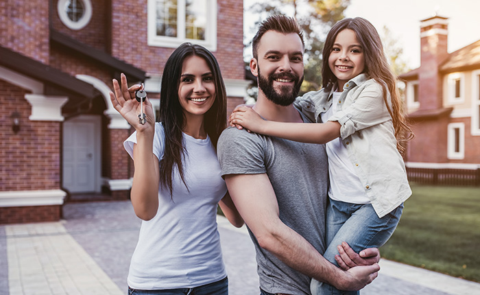 couple taking selfie in front of sold sign